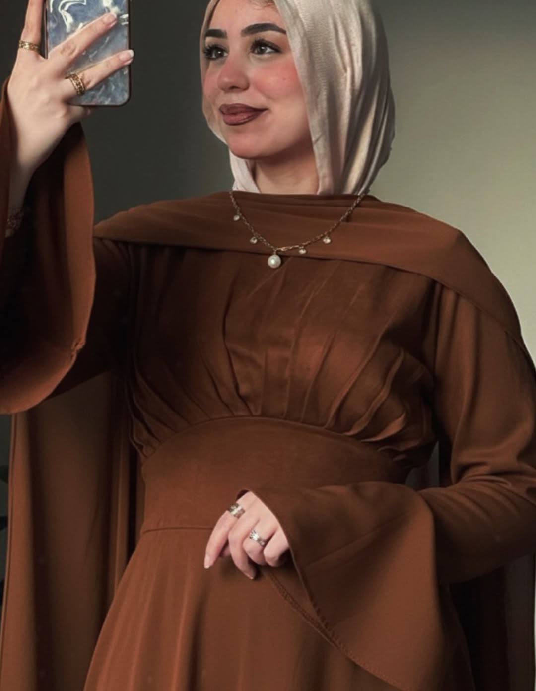 فستان "شمواه سويدي" بشال شيفون وأكمام واسعة.